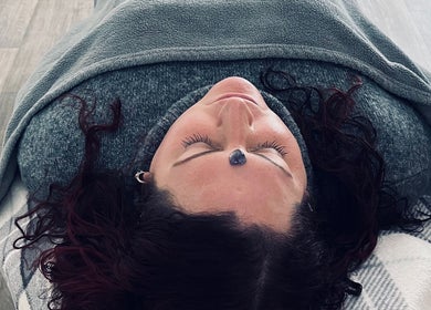 Person enjoying crystal healing session at Aura and Earth, Taunton, England, GB, with a serene expression.