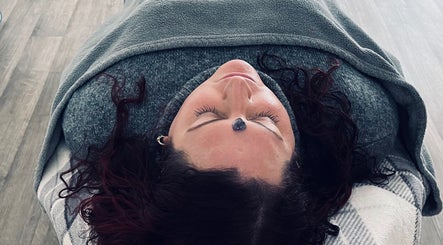 Person enjoying crystal healing session at Aura and Earth, Taunton, England, GB, with a serene expression.