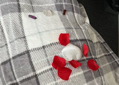 Aura and Earth venue in Taunton, England, GB, showcasing red petals and crystals on a plaid blanket.