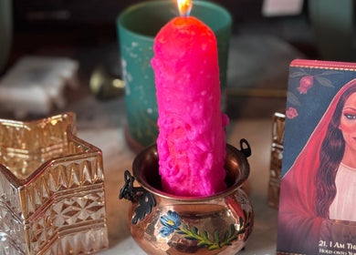 Vibrant pink candle in copper pot at Aura and Earth, Taunton, England, GB surrounded by decor.