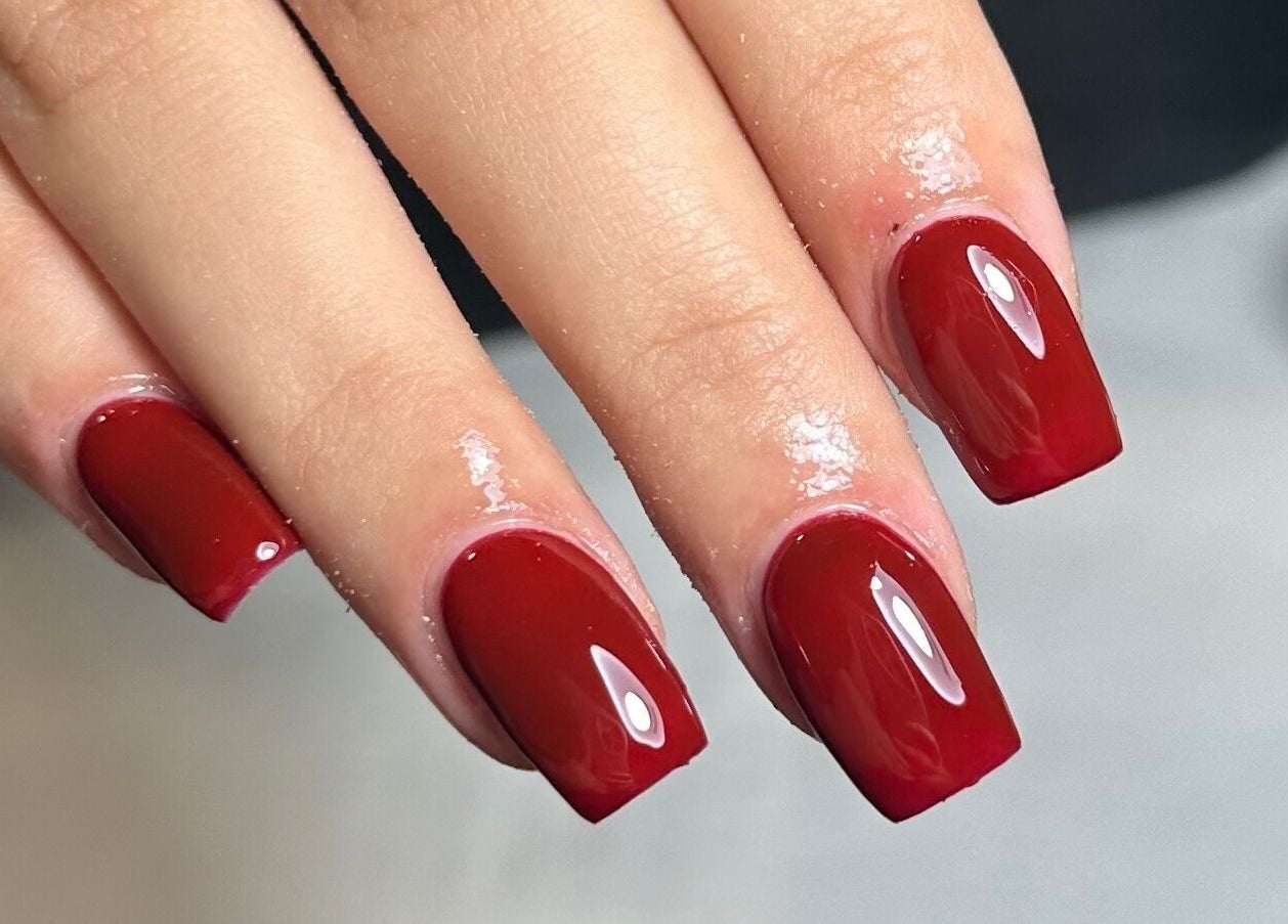 Stylish red manicure at Libby’s Beauty, Welcombe, England, GB, nails shine brilliantly.