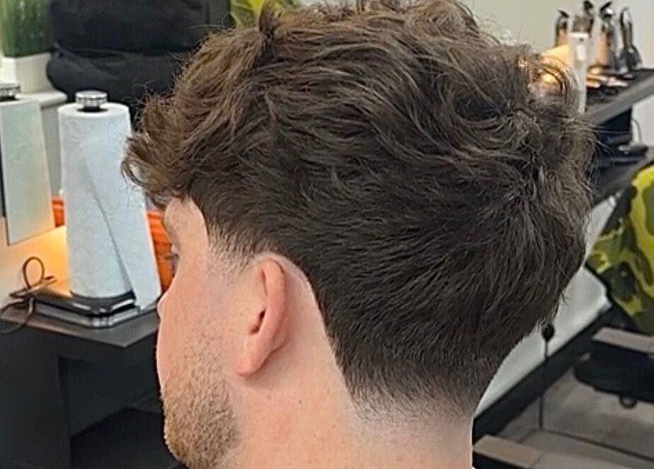 A fresh haircut shown at Bez Barber, Birmingham, England, GB with modern decor in the background.