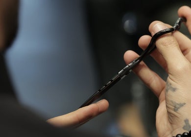 Close-up of a stylist holding precision shears at Cutz Hair Studio, Riyadh, SA, showcasing craftsmanship.