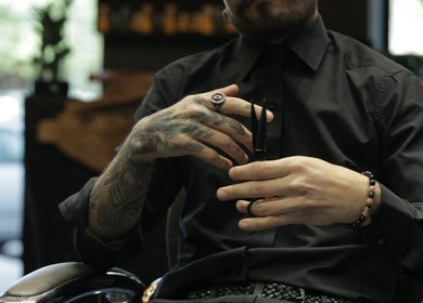 Barber styling hair with precision at Cutz Hair Studio, Riyadh, SA for a sleek look.