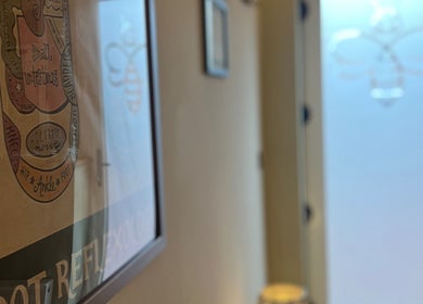 Cozy hallway at Humblebee Wellness, Saint Leonards, England, featuring wall art and soft lighting.