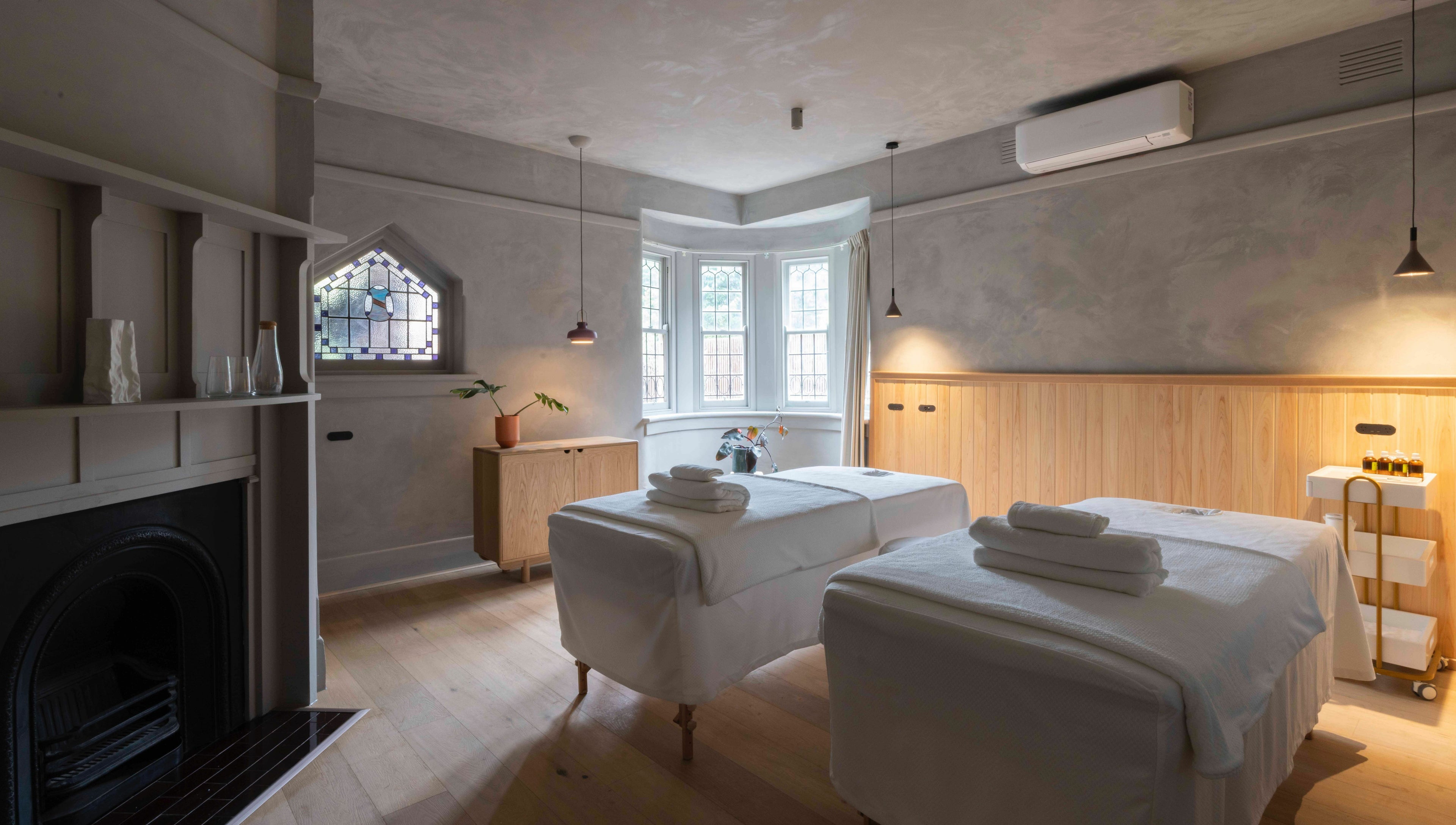 Relaxing massage room at In the Brick Spa, Melbourne, Victoria, AU, featuring twin beds and ambient lighting.