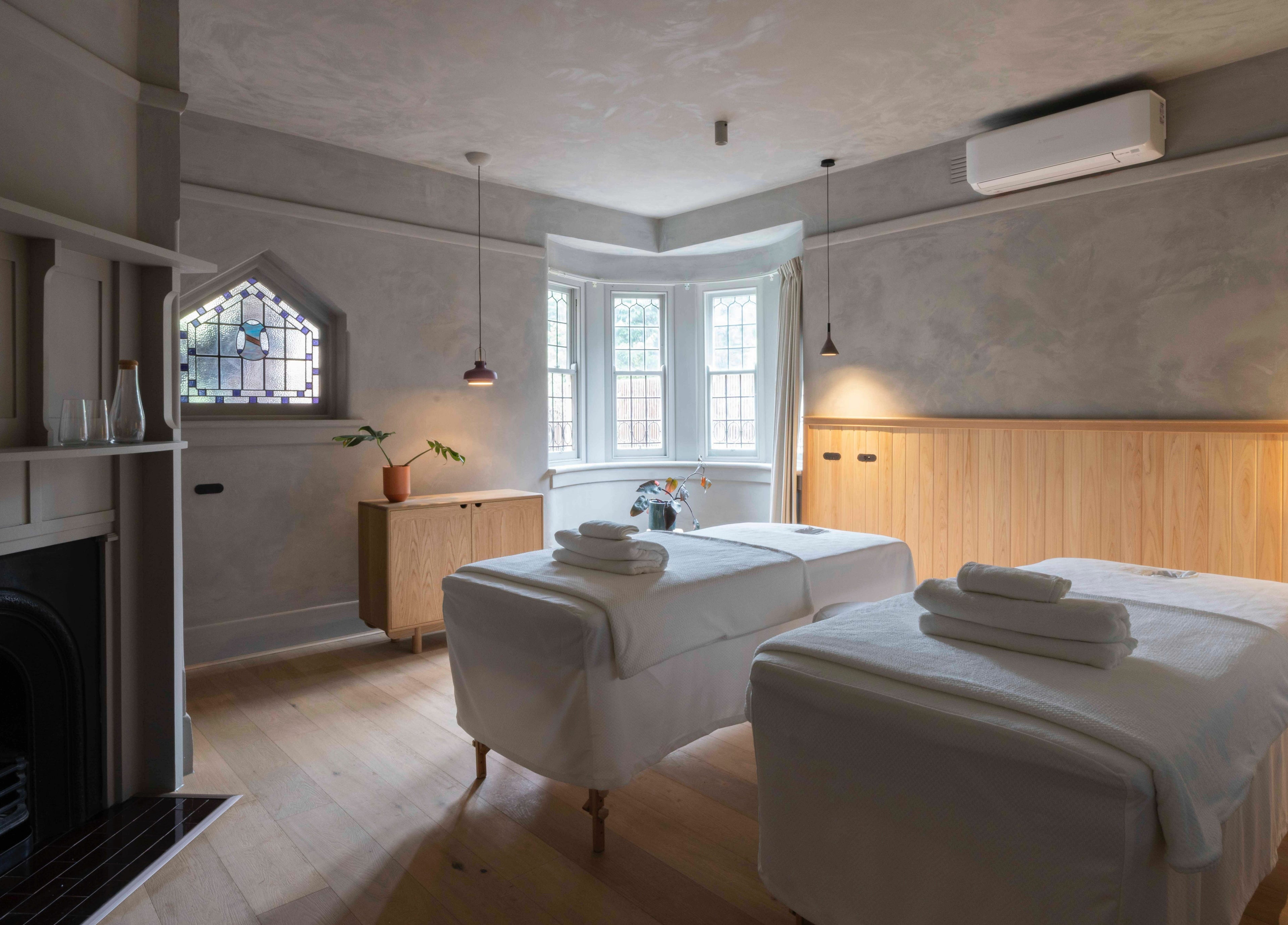 Relaxing massage room at In the Brick Spa, Melbourne, Victoria, AU, featuring twin beds and ambient lighting.