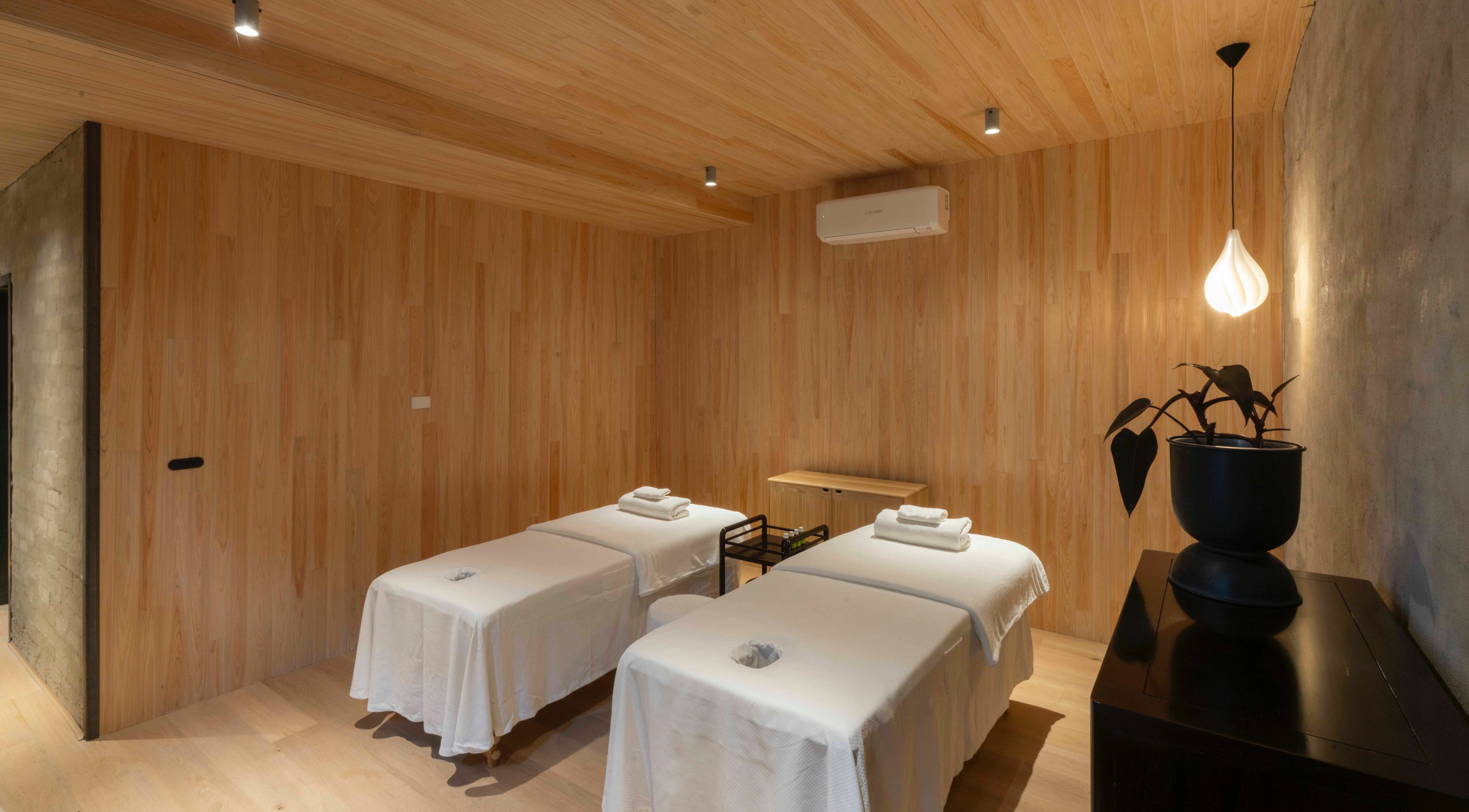 Relaxing massage room at In the Brick Spa, Melbourne, Victoria, AU with two beds under soft lighting.