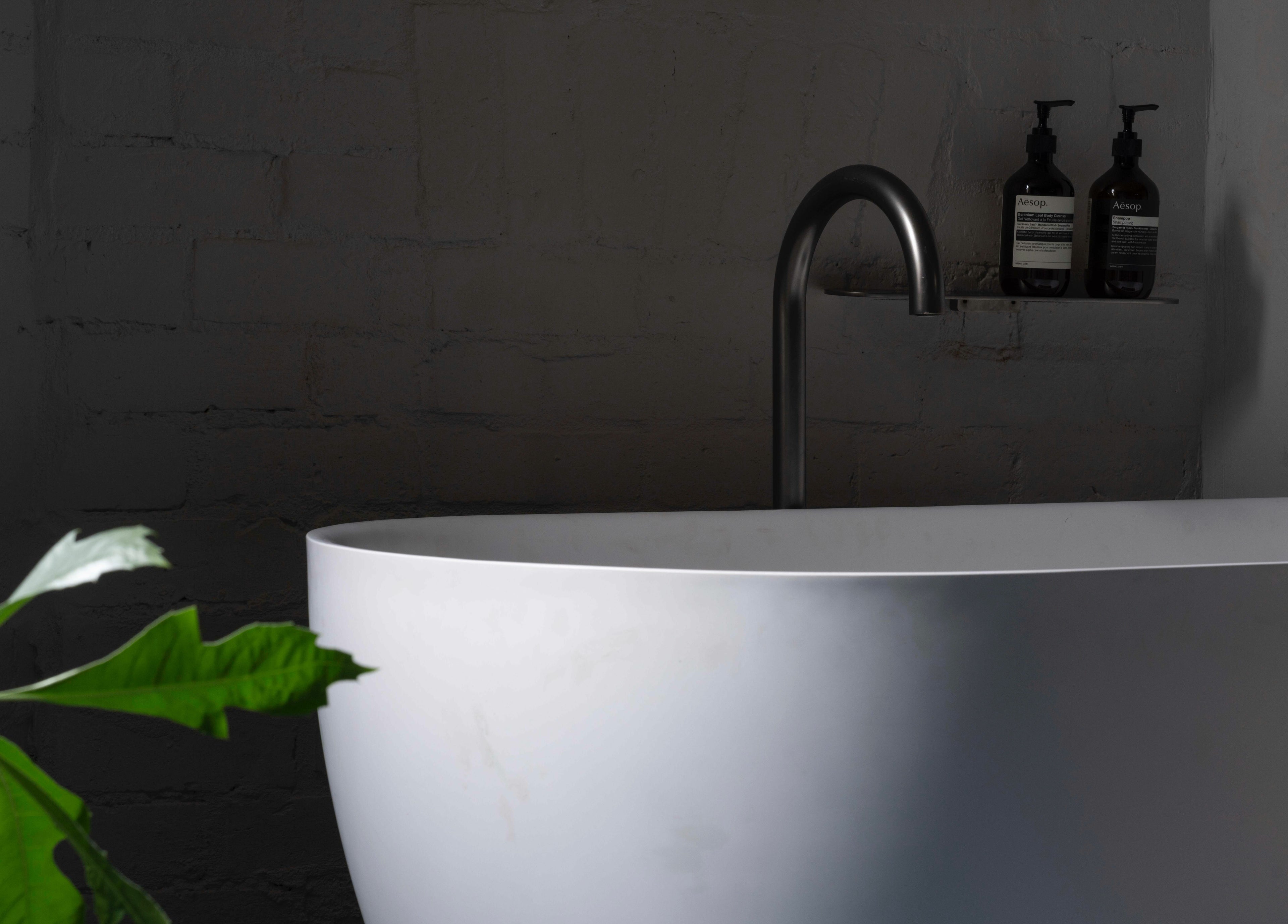 Luxurious bathtub with plant and products at In the Brick Spa, Melbourne, Victoria, AU.