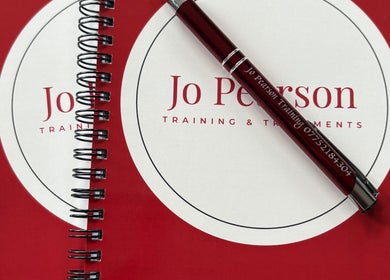 Red notebooks and pen with Jo Pearson Training & Treatments logo at Carr Gate, England, GB.
