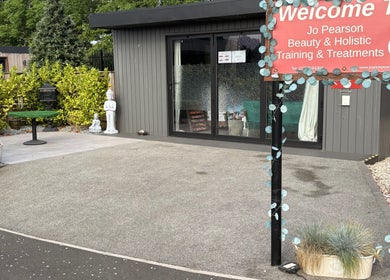 Entrance to Jo Pearson Training & Treatments at Carr Gate, England, GB with garden decor and inviting sign.