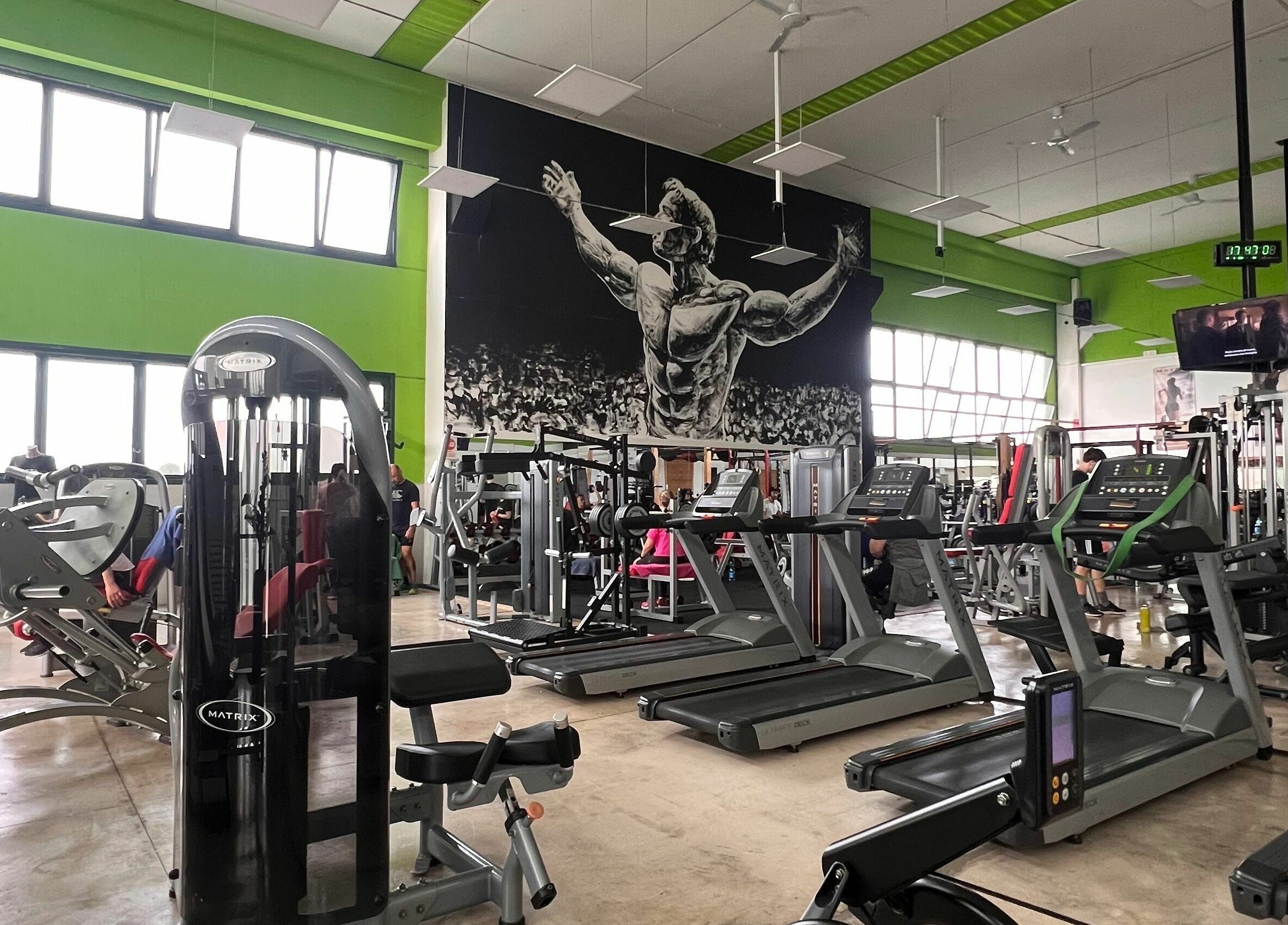 Interno della palestra Fiit Zone Centro Fitness a Lograto, Lombardia, IT, con attrezzature moderne e murale ispiratore.