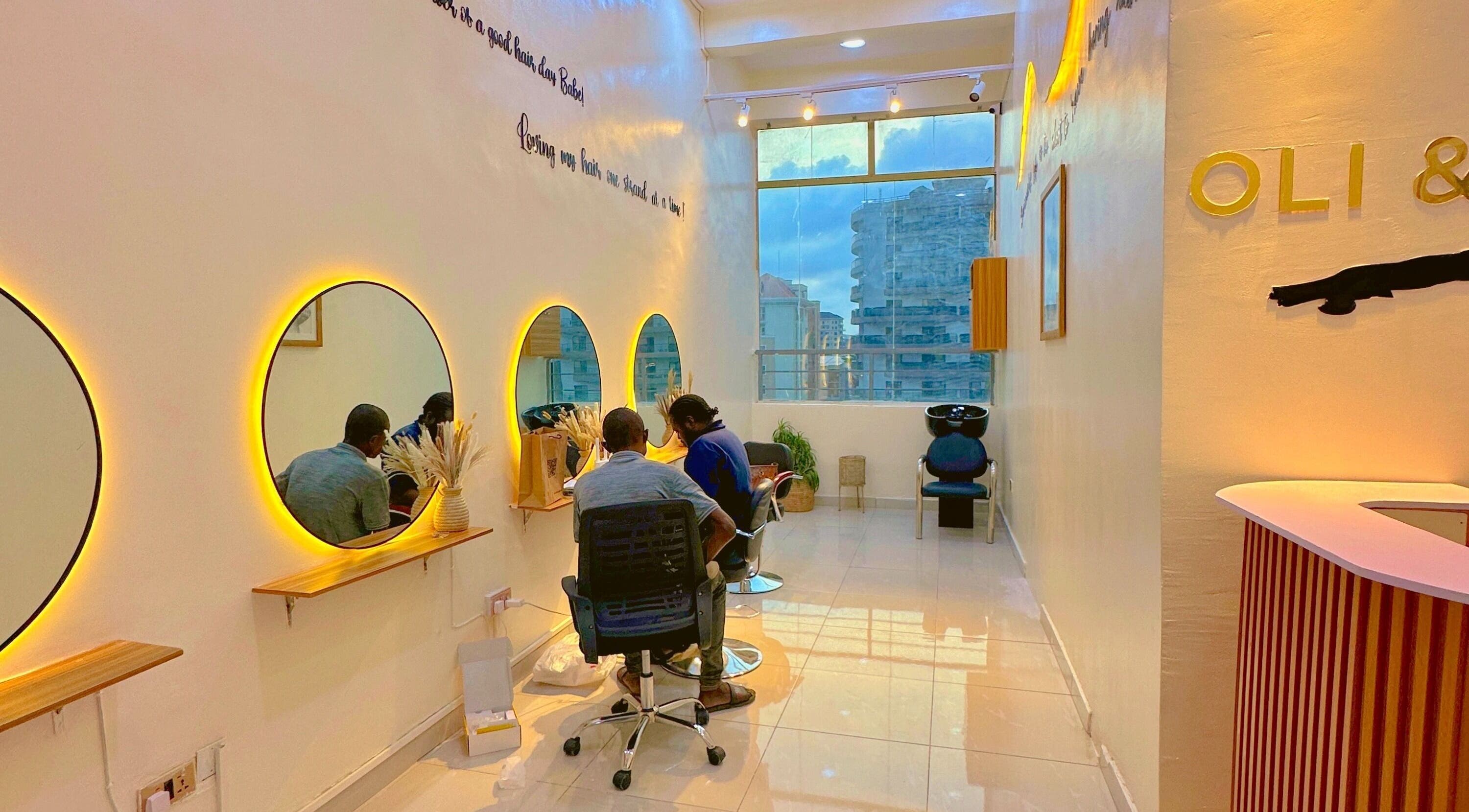 Stylish interior of O&Y Braiding Bar in Lagos, Lagos, NG with glowing mirrors and client chairs.
