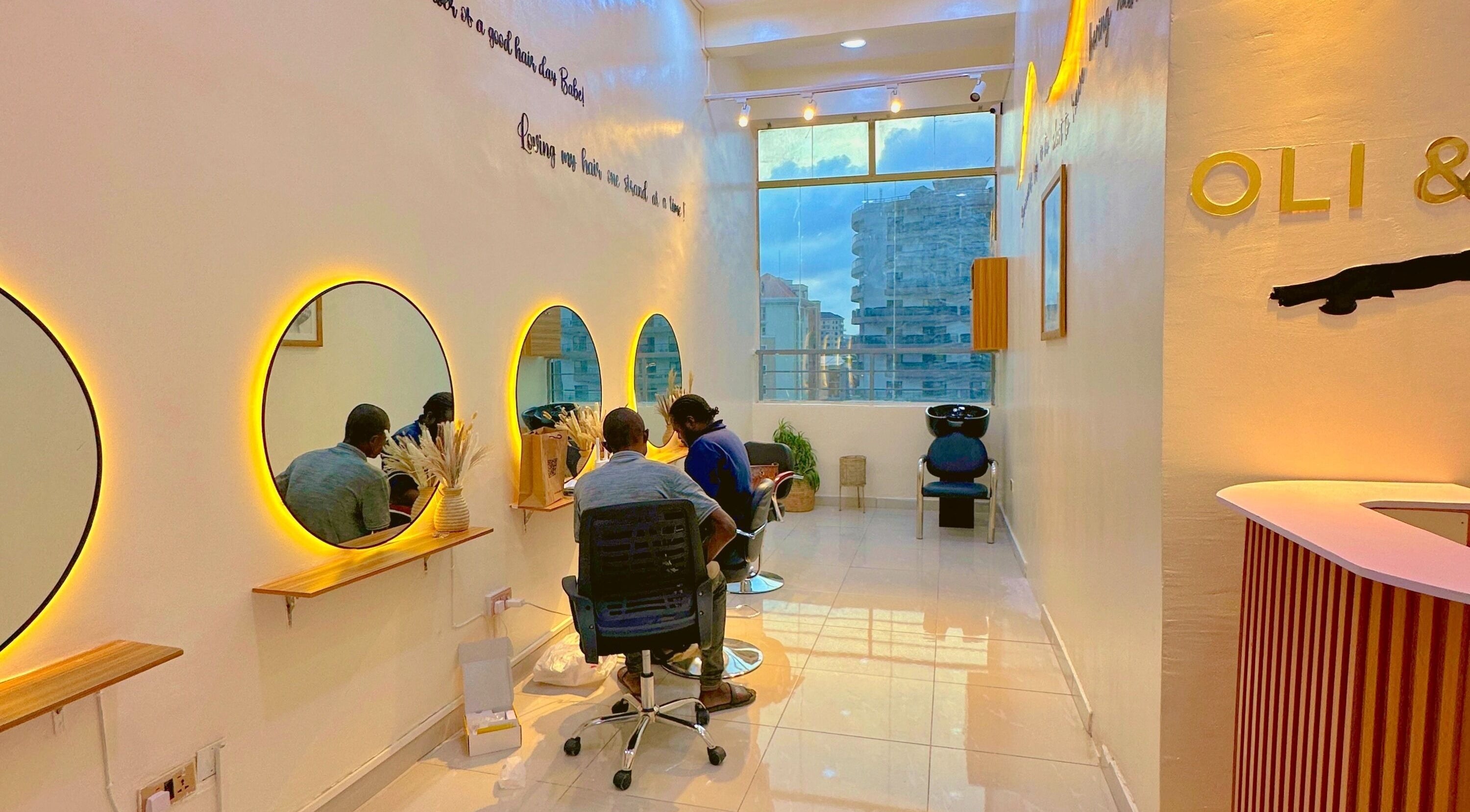 Stylish interior of O&Y Braiding Bar in Lagos, Lagos, NG with glowing mirrors and client chairs.