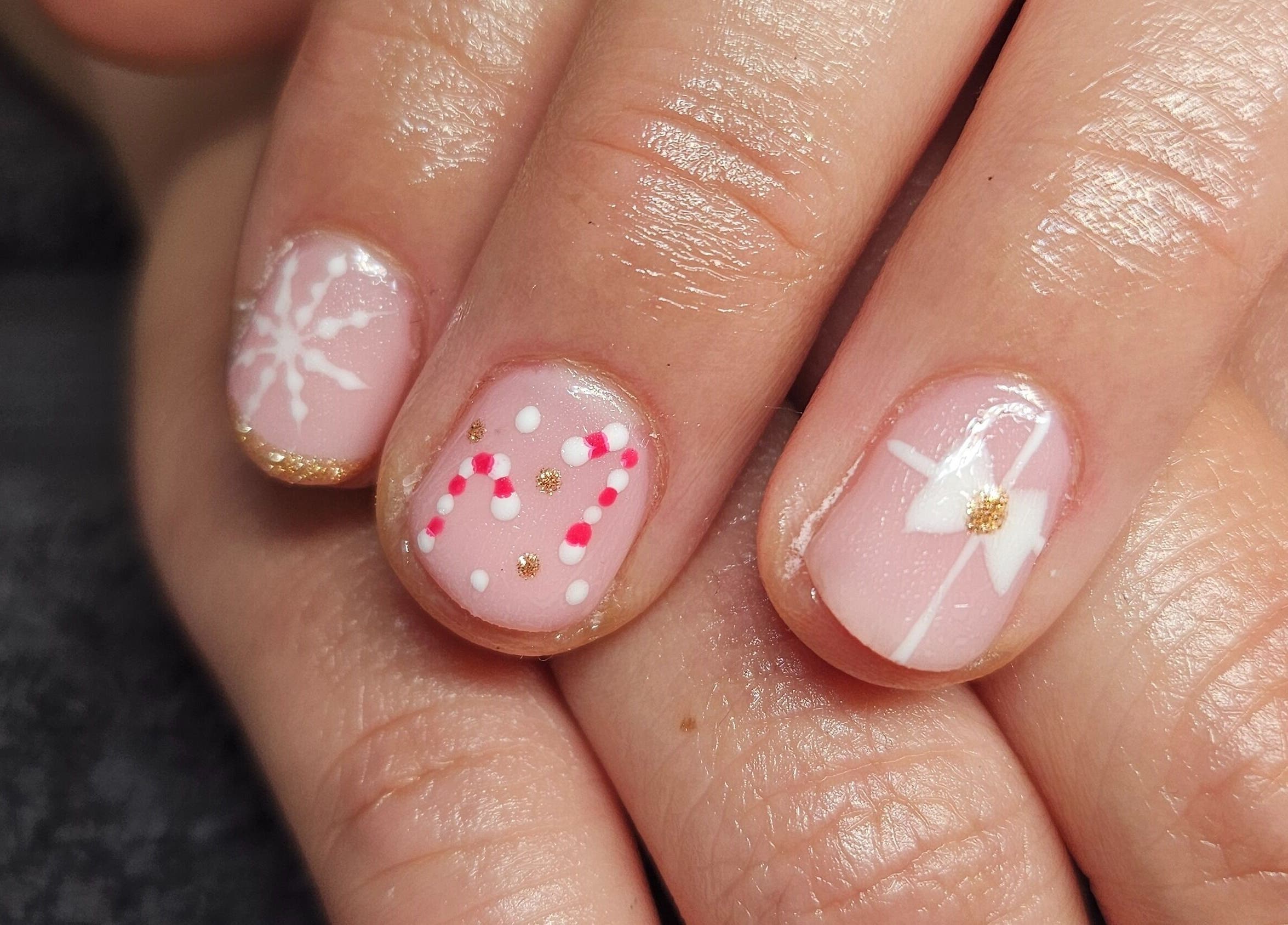 Creative festive nail art at Hannah's Be You Beauty in Norwich, England, GB featuring candy cane and snowflake designs.
