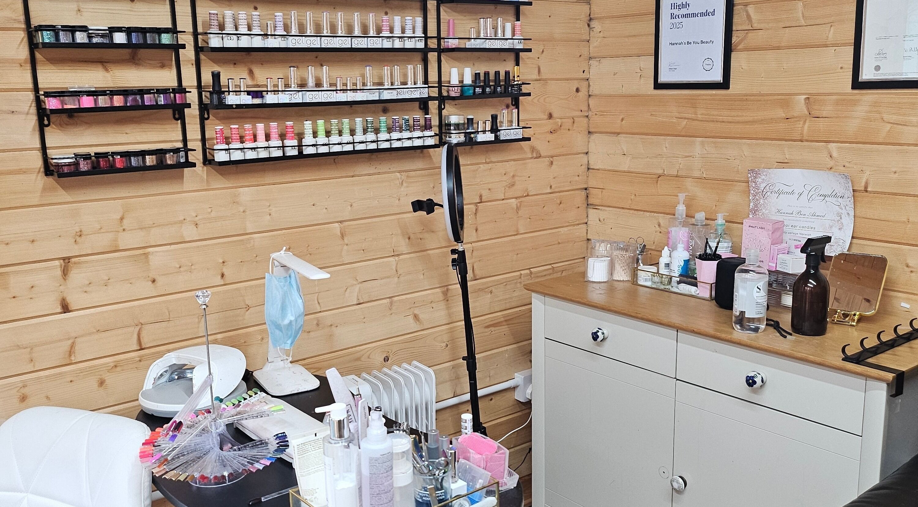 Nail polish display at Hannah's Be You Beauty, Norwich, England, GB. Cozy wooden interior evokes calm.