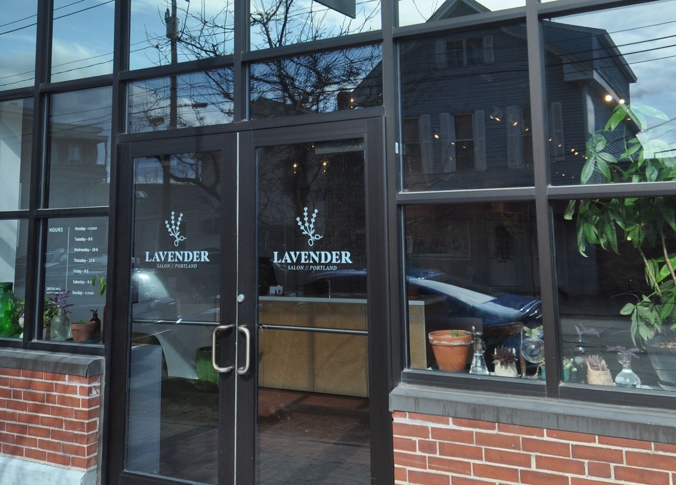 Entrance of Lavender salon in Portland, Maine, US, showcasing glass doors and a vibrant window display.