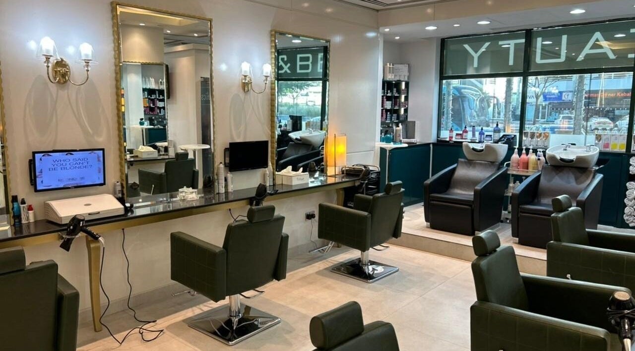 Modern interior of Osama Kasir Beauty Salon and Barbershop in Dubai, AE, featuring styling stations and washing chairs.