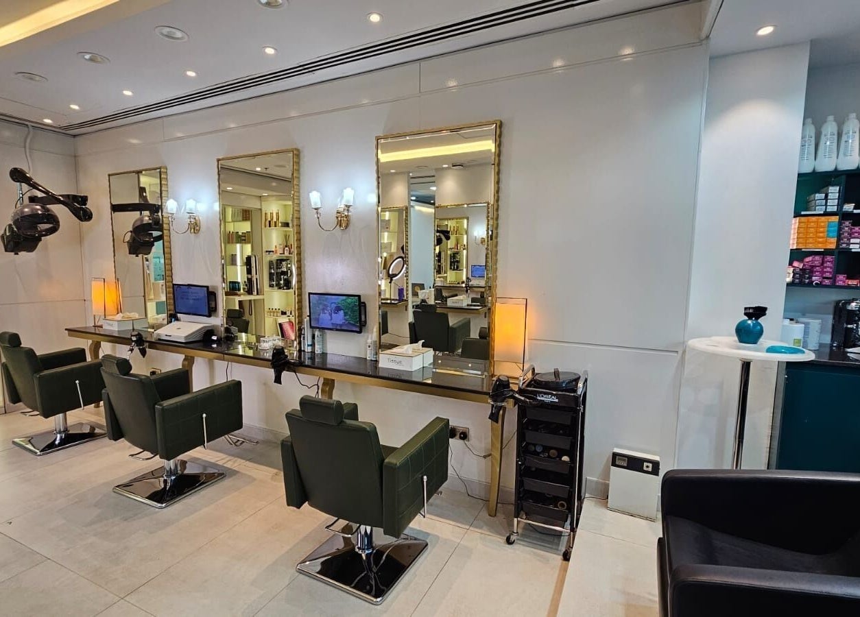 Chic styling area at Osama Kasir Beauty Salon and Barbershop in Dubai, AE with modern chairs and mirrors.