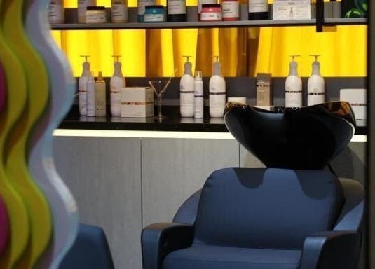 Hair salon station at 360 Beauty Lounge, Sharjah, AE with vibrant decor and product shelves.