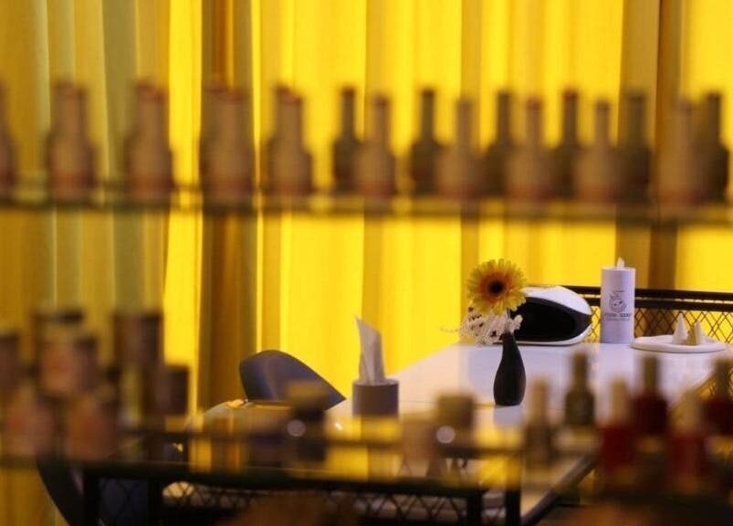 Elegant table setup with bright yellow curtains at 360 Beauty Lounge, Sharjah, Sharjah, AE.