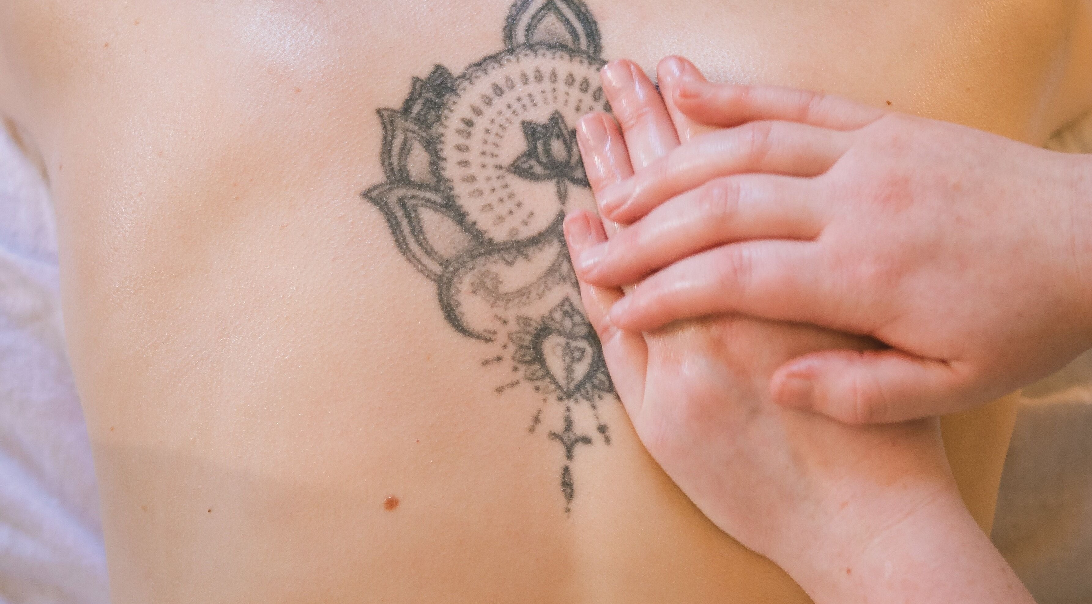Tattooed back receiving calming massage at Ruby's Refuge at The Calstock Therapy Hub, Calstock, England, GB.