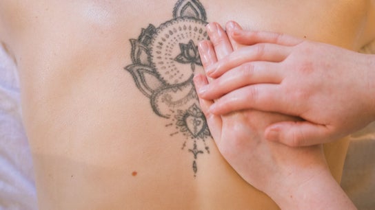 Tattooed back receiving calming massage at Ruby's Refuge at The Calstock Therapy Hub, Calstock, England, GB.