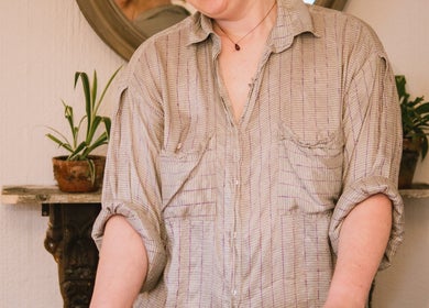 Therapist at Ruby's Refuge, Calstock, England, creating a calming atmosphere with plants and gentle expression.
