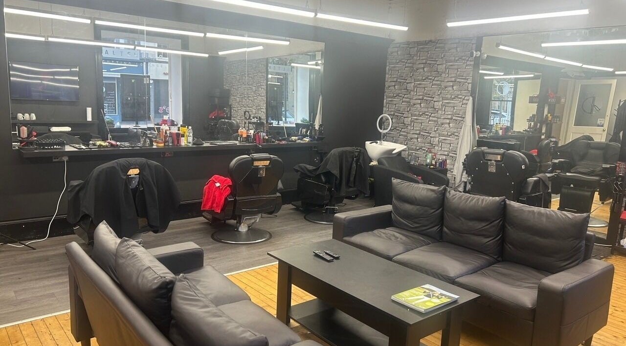 Interior of Alter Ego in Ayr, Scotland, GB showing modern black seating and styling stations.