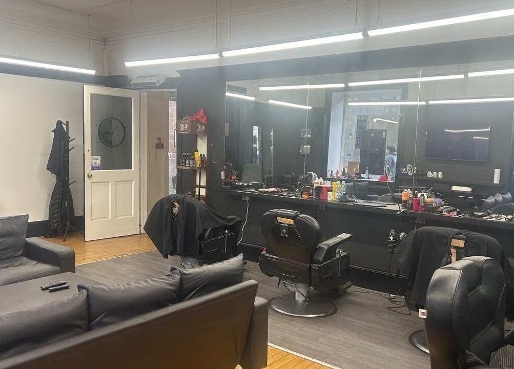 Modern barber salon Alter Ego in Ayr, Scotland, GB with black chairs, mirrors, and cozy seating.