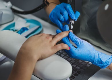 Manicure in progress at Salon White Blue, Edmonton, Alberta, CA by a professional in blue gloves.