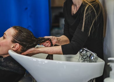 Woman enjoying a hair wash at Salon White Blue in Edmonton, Alberta, CA.