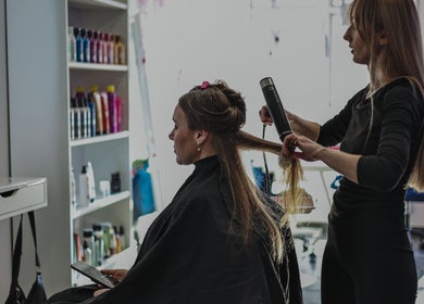 Expert stylist working on client's hair at Salon White Blue, Edmonton, Alberta, CA. Modern salon atmosphere.