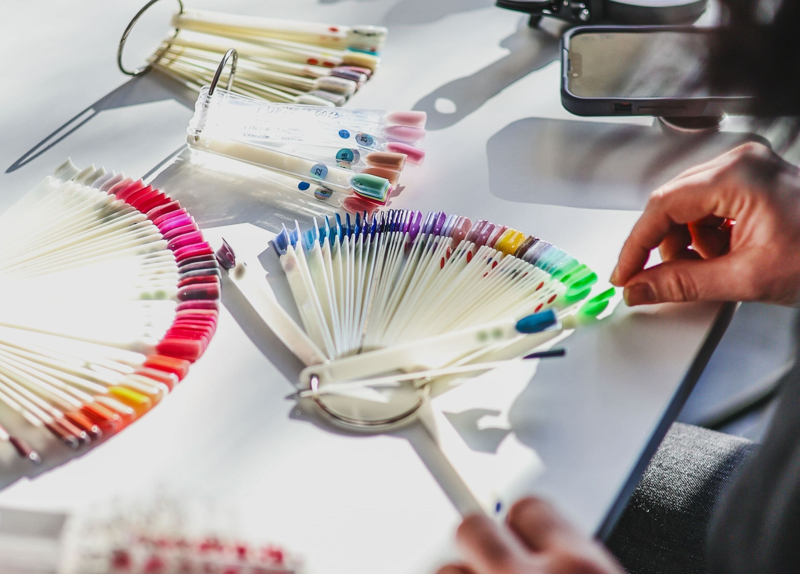 Colorful nail palettes at Salon White Blue, Edmonton, Alberta, CA showcasing a variety of polish shades.