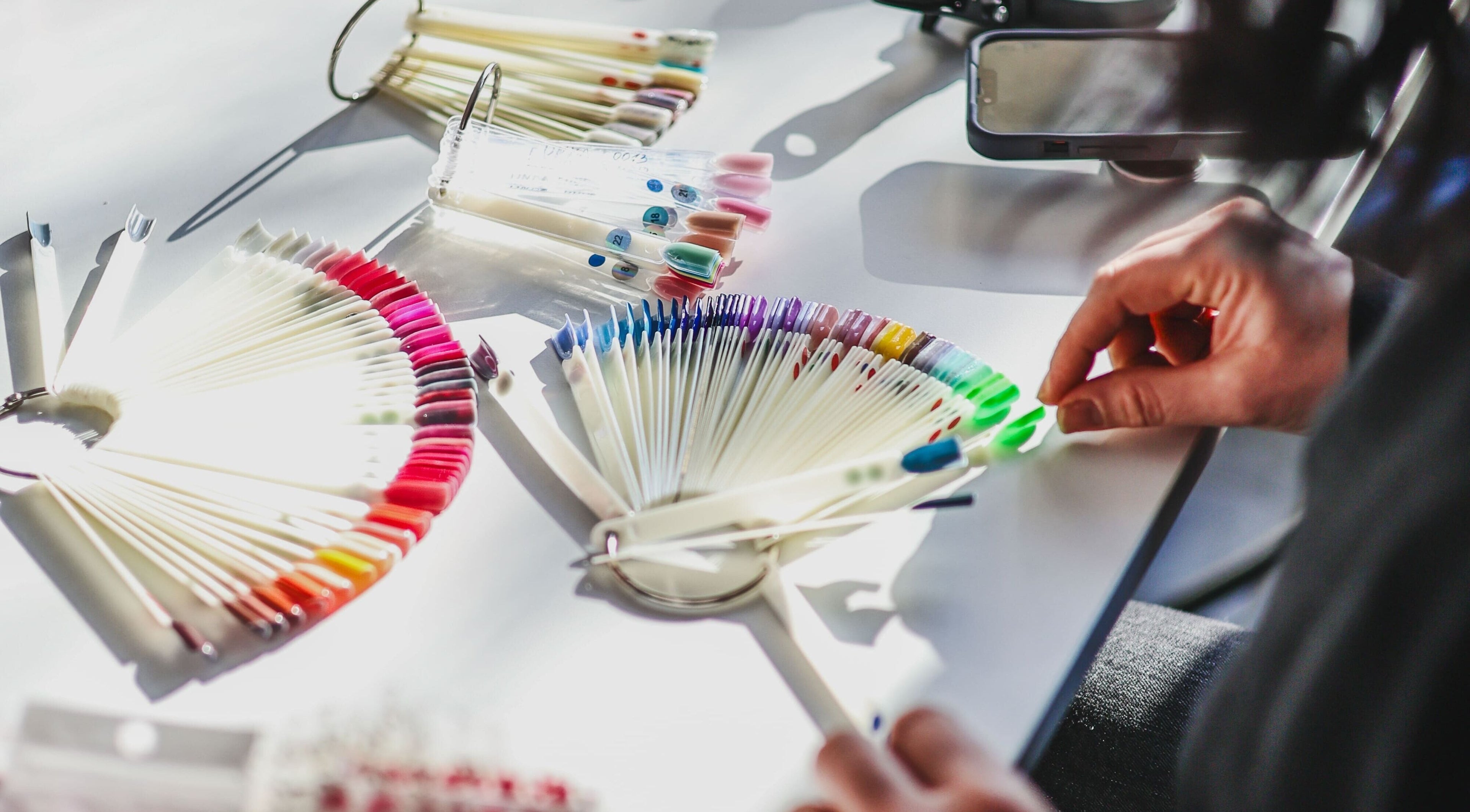 Colorful nail palettes at Salon White Blue, Edmonton, Alberta, CA showcasing a variety of polish shades.