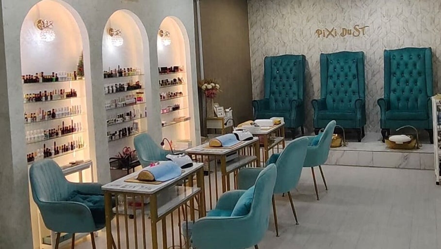 Chic interior of Pixi Dust salon in Kuala Lumpur, featuring luxurious turquoise chairs and modern nail stations.