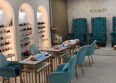 Chic interior of Pixi Dust salon in Kuala Lumpur, featuring luxurious turquoise chairs and modern nail stations.