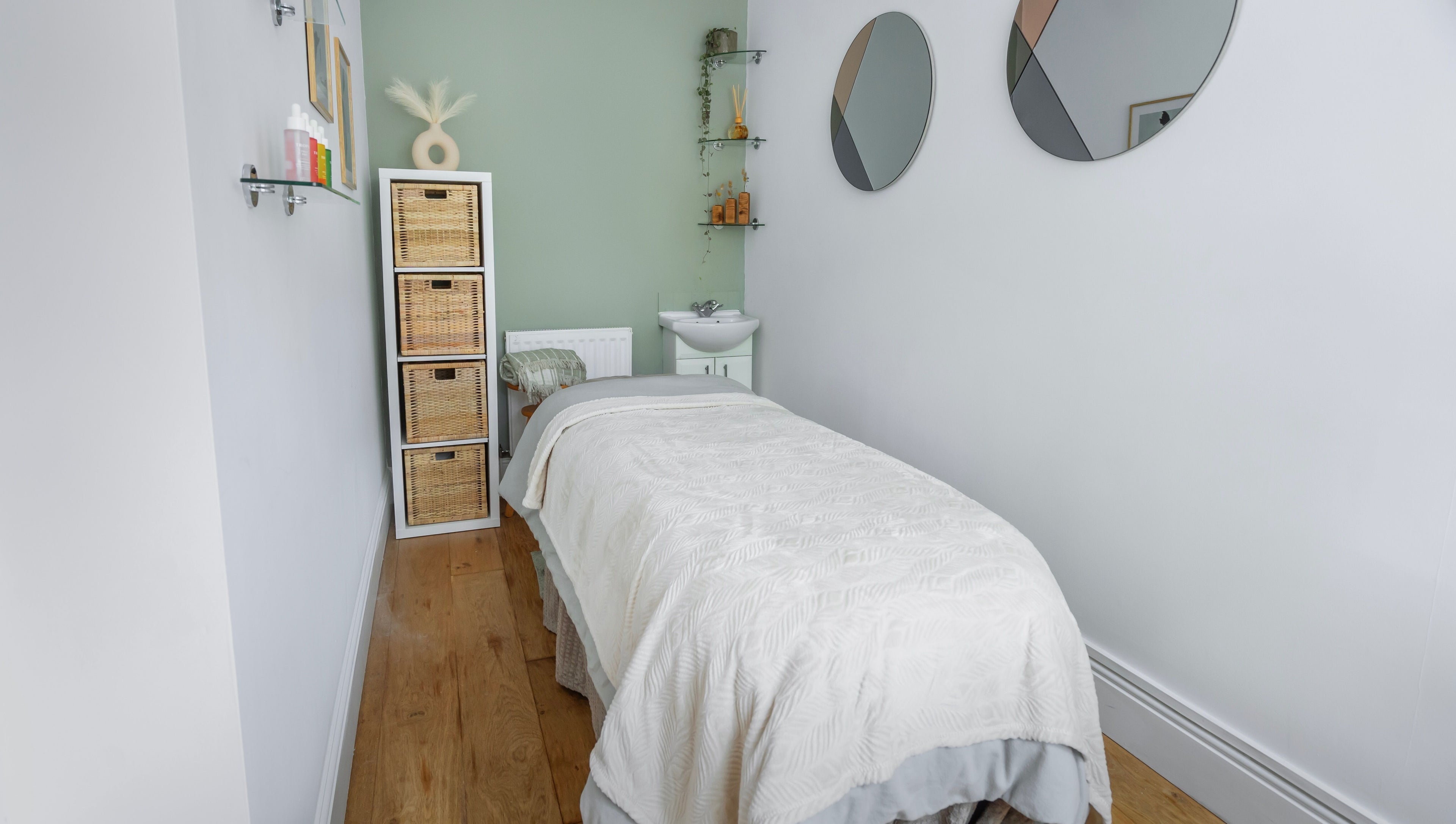 Relaxing massage room at Sage Massage, Wilmslow, England, GB with a cozy bed and serene decor.