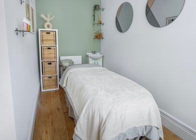 Relaxing massage room at Sage Massage, Wilmslow, England, GB with a cozy bed and serene decor.