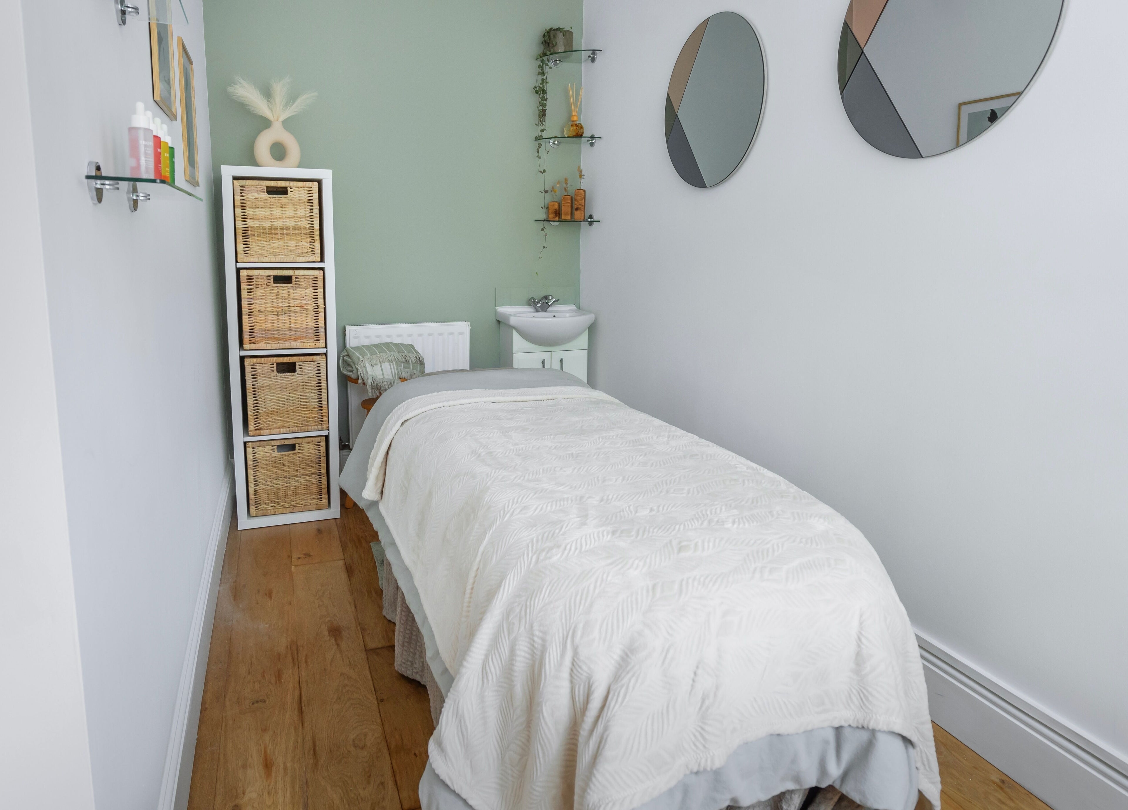 Relaxing massage room at Sage Massage, Wilmslow, England, GB with a cozy bed and serene decor.