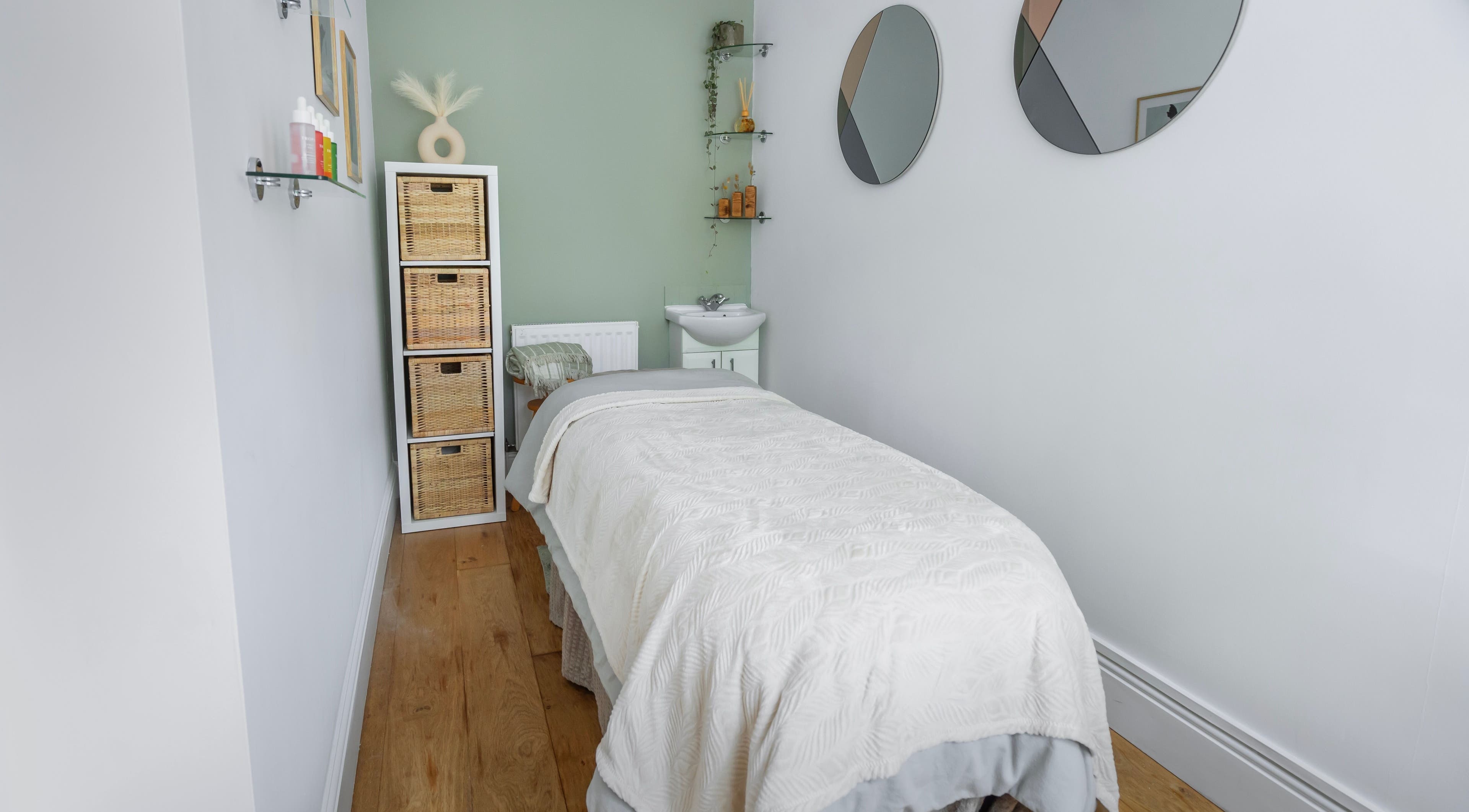 Relaxing massage room at Sage Massage, Wilmslow, England, GB with a cozy bed and serene decor.