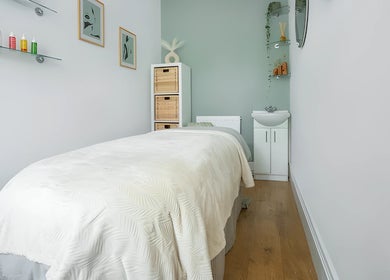 Tranquil massage room at Sage Massage, Wilmslow, England, GB, showcasing a cozy bed and calming decor.