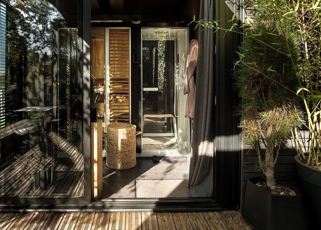 Entrée paisible de Le Cube Massages & Spa à Jouey, Bourgogne-franche-comté avec plantes luxuriantes.