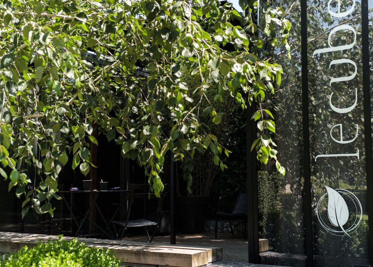 Entrée sereine de Le Cube Massages & Spa à Jouey, Bourgogne-franche-comté, FR, entourée de verdure.