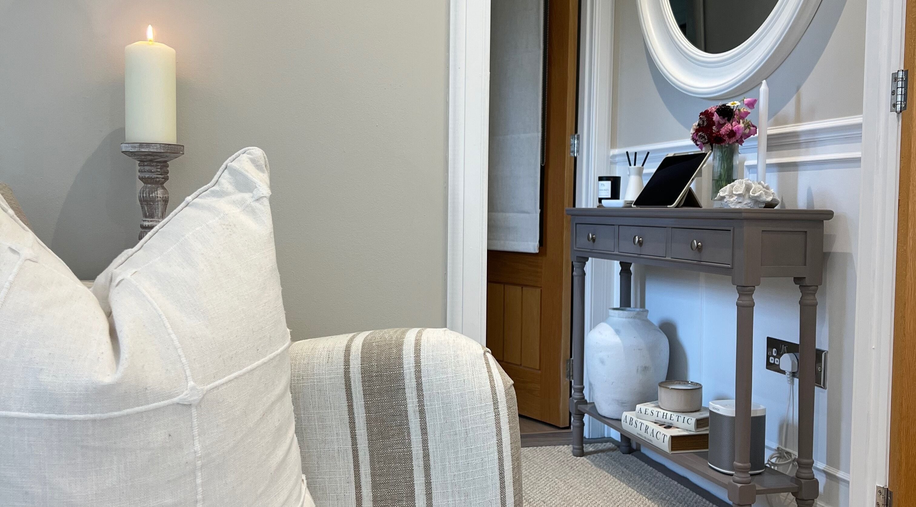 Elegant interior of Boutique Beauty by Alice, Invergordon, Scotland, GB, featuring a candlelit console and plush pillows.