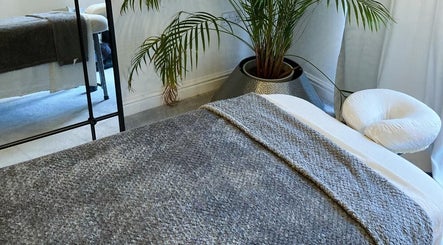 Serene massage room at Waseley Wellbeing in Worcestershire, GB with cosy bedding and calming decor.