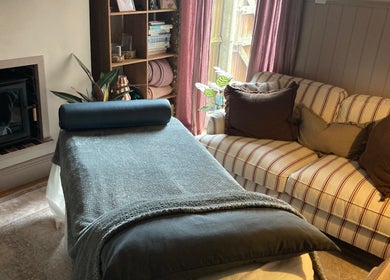 Serene massage room at Waseley Wellbeing, Worcestershire, GB with plush sofa and soft lighting.