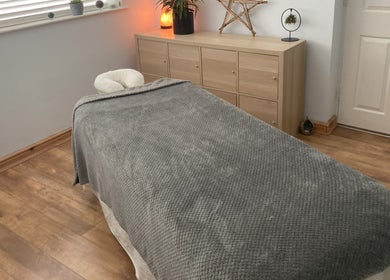 Serene massage room at Waseley Wellbeing, Worcestershire, GB featuring a cozy treatment bed and calming decor.