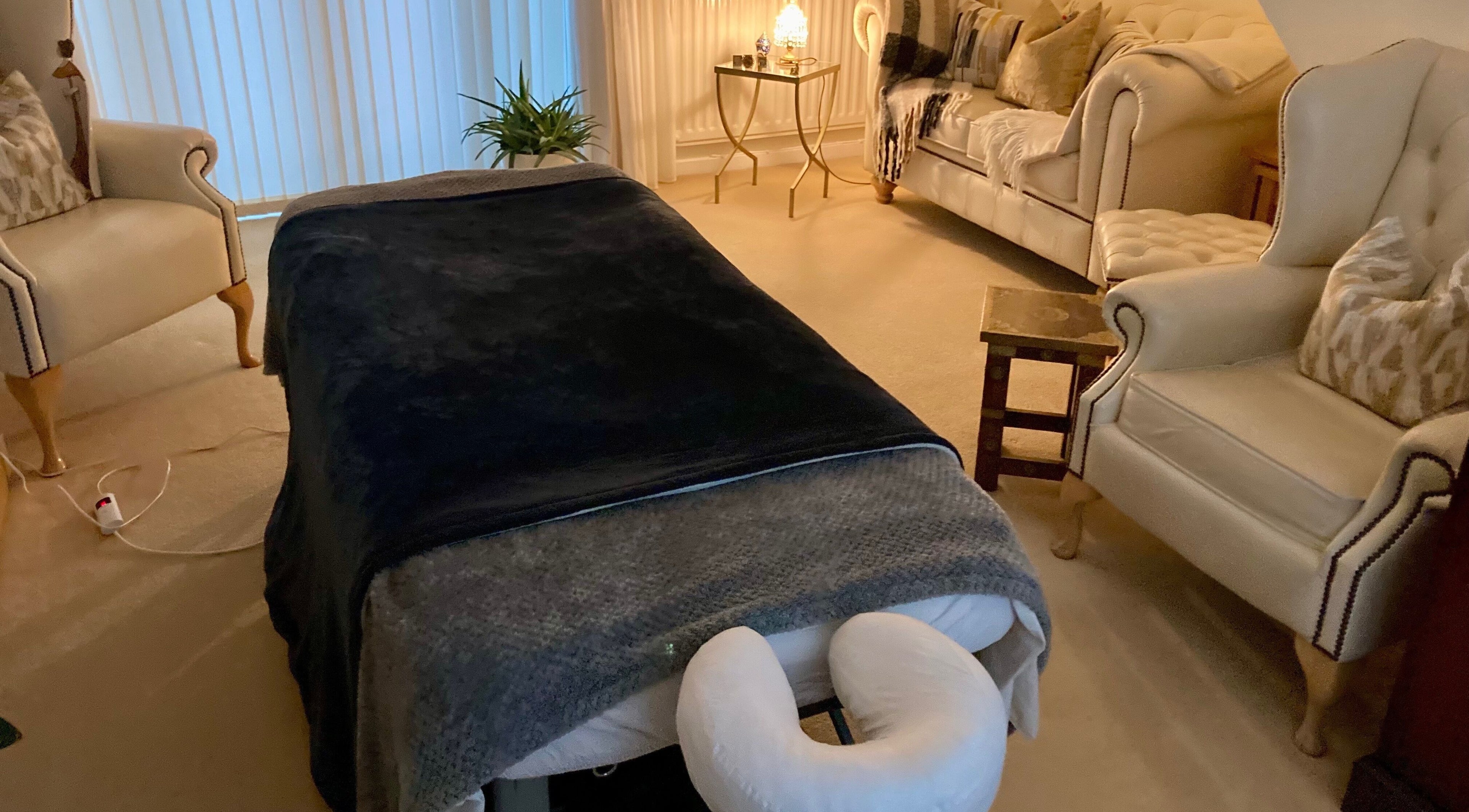 Cozy massage room at Waseley Wellbeing, Worcestershire, GB with warm lighting and comfortable seating.