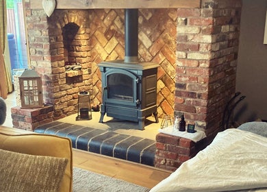Inviting brick fireplace at Waseley Wellbeing in Worcestershire, GB, creating a warm and cozy atmosphere.